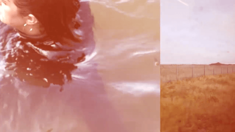 Film still of a split screen, hazy orange, a train journey on the right, a person floating in water wearing black on the left