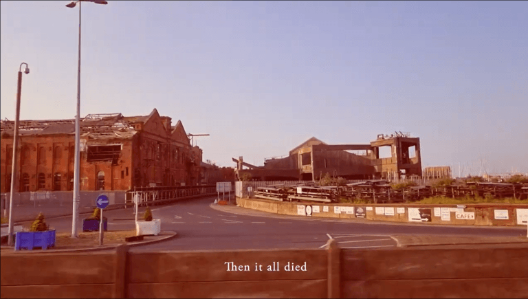 Still of a film, Grimsby Ice House at the docks, dilapidated in the background.